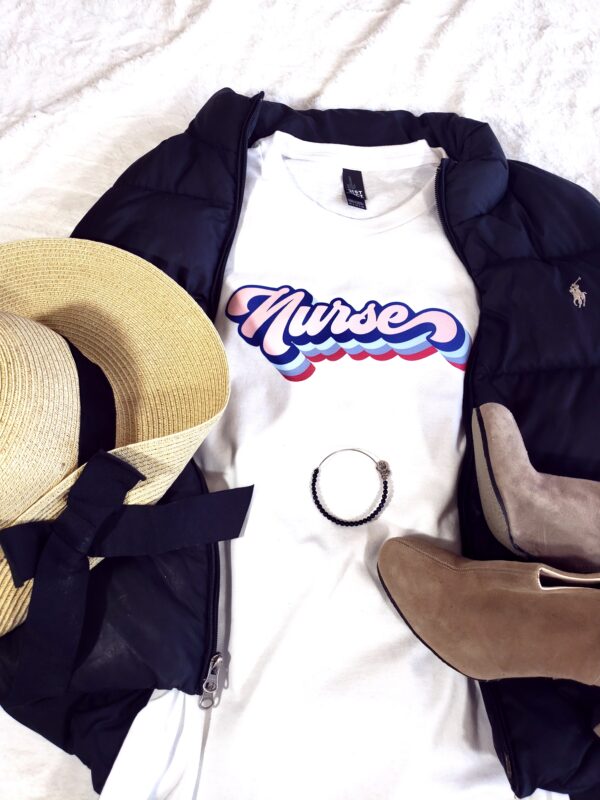Straw Hat with Black Bow, Puffer Vest, white tshirt that says nurse in retro font, black bangle bracelet, and tan mules