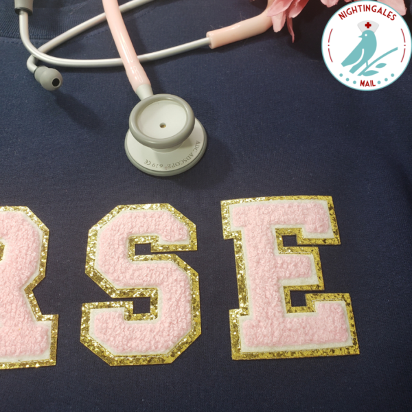 Nurse sweatshirt in navy with pink chenille letters that spell out NURSE